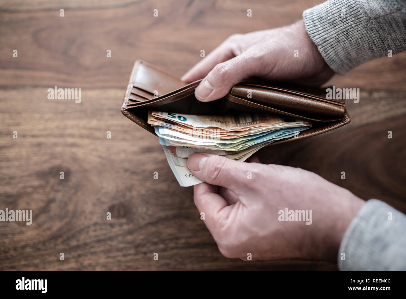 Person zählen Stapel Papier Bargeld in der Brieftasche Stockfoto