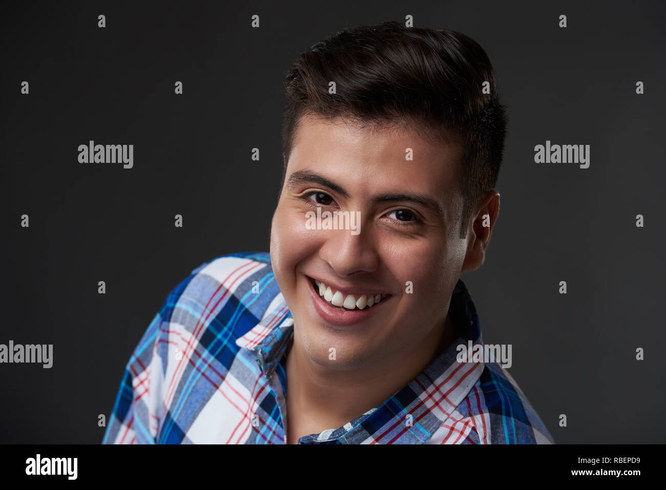 Portrait von Glücklich lächelnde junge Mann im casual Outfit auf Grau studio Hintergrund Stockfoto