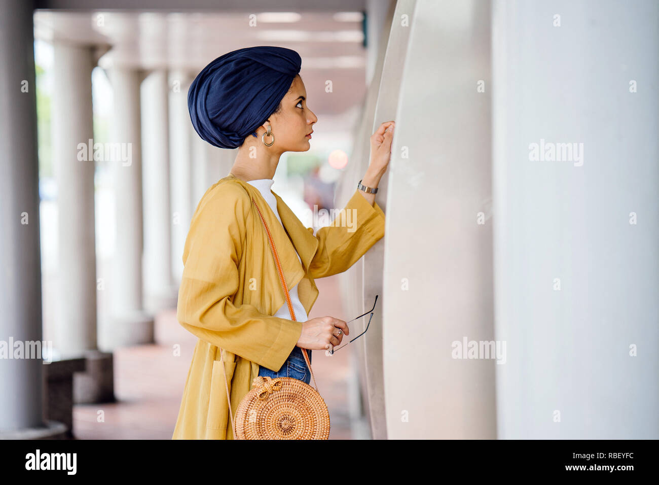 Ein junge muslimische asiatische Frau aus dem Nahen Osten Abstieg in einem stilvollen trendy Outfit und ein Turban (HIJAB) konsultiert eine Karte, um den Bus zu nehmen. Stockfoto