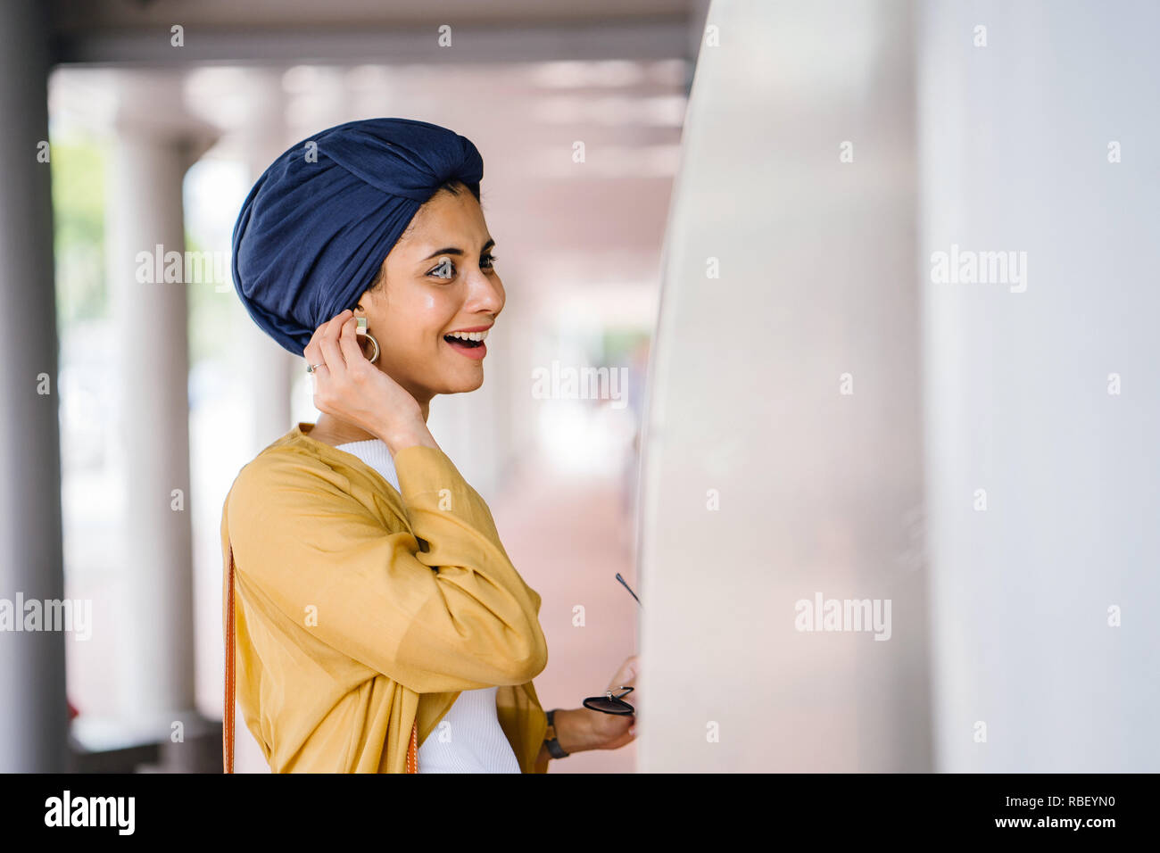 Ein junge muslimische asiatische Frau aus dem Nahen Osten Abstieg in einem stilvollen trendy Outfit und ein Turban (HIJAB) konsultiert eine Karte, um den Bus zu nehmen. Stockfoto