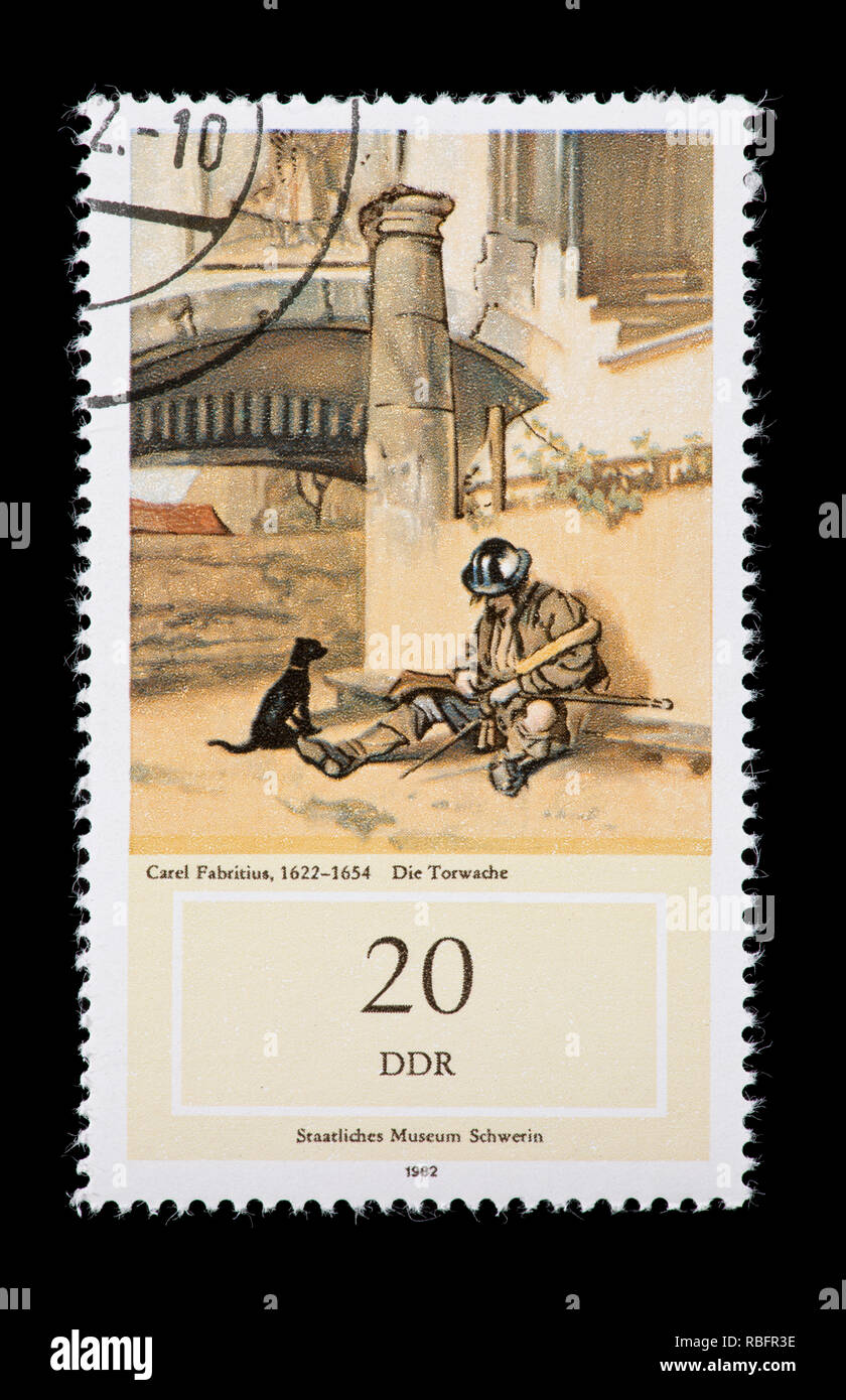 Briefmarke aus Ostdeutschland (DDR), die die Carel Fabritius Malerei das Tor hüten. Stockfoto