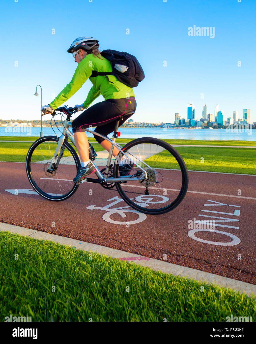 Männliche Radfahrer, reiten ein Zyklus nur Radweg/Radweg mit Perth Skyline der Stadt in der Ferne Stockfoto