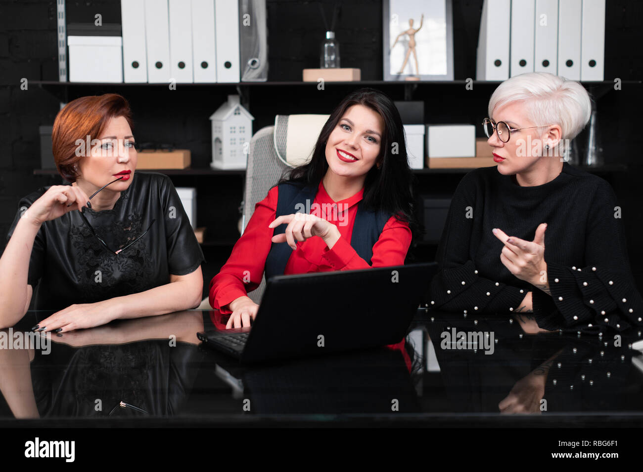 Drei weiblichen Kollegen im Büro am Tisch mit Laptop Stockfoto