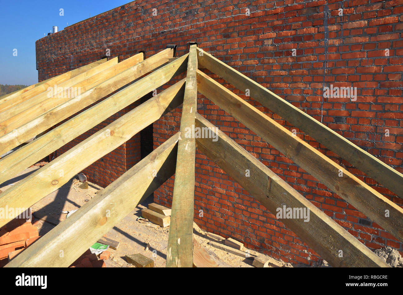 Dach- Konstruktion. Nahaufnahme auf hölzernen Sparren, Traufe, Holzbalken installiert auf Mauer mit Bitumen Abdichtung und metallanker an Stockfoto