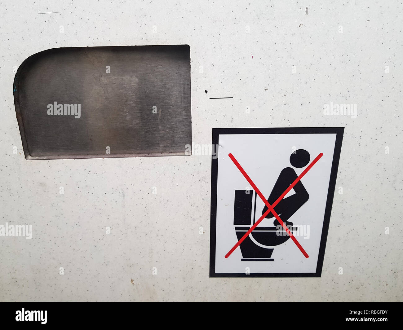 'Don't auf dem WC-Sitz' Zeichen in einem schmutzigen öffentliche Toilette stand Stockfoto
