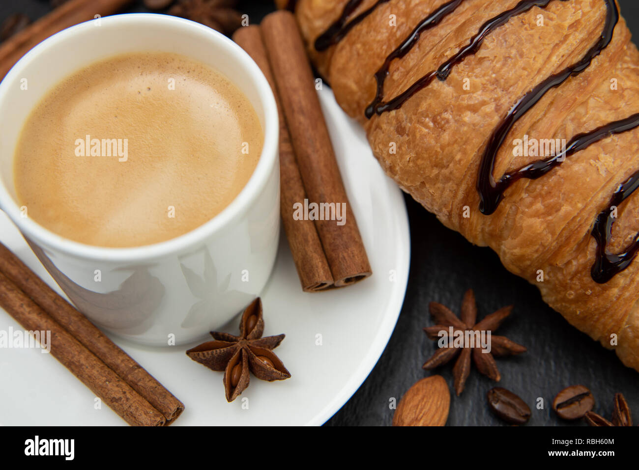 Frühstück. Kaffee mit Croissant dekoriert mit Zimt Stacheln und Sternanis. Stockfoto