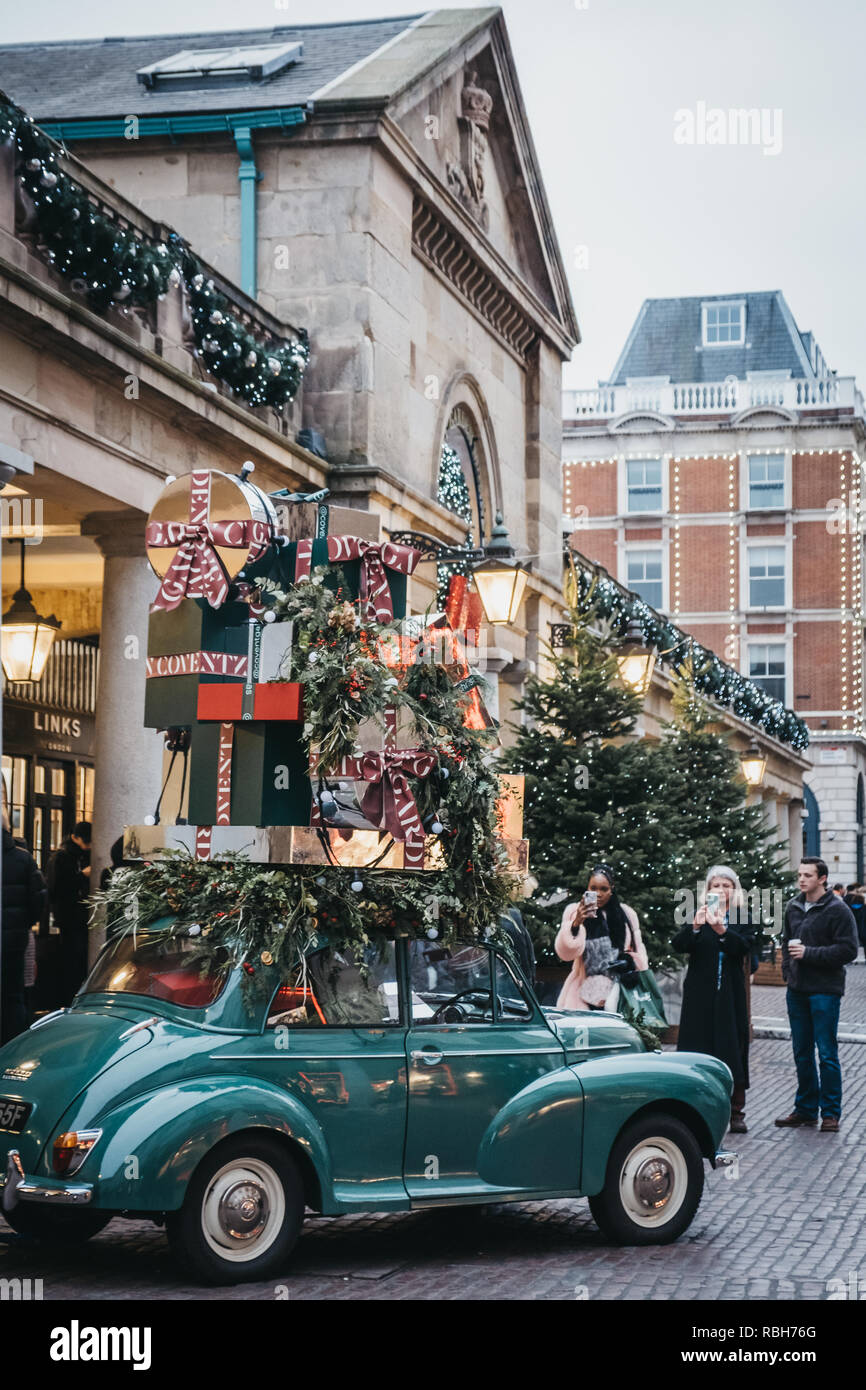 London, Großbritannien - 5. Januar 2019: Leute, die Fotos von einem Auto mit präsentiert Christbaumschmuck in Covent Garden Market, einer der beliebtesten Tour Stockfoto