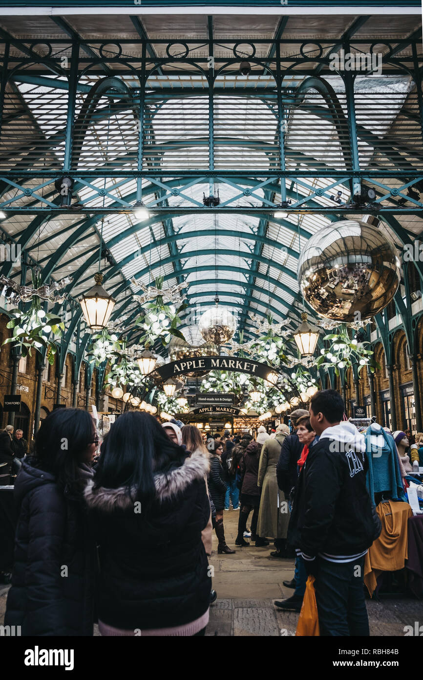 London, UK - Januar 5,2019: die Menschen gehen unter Apple Markt Zeichen mit Weihnachtsschmuck und einer riesigen Kugeln in Covent Garden Market eingerichtet, auf Stockfoto