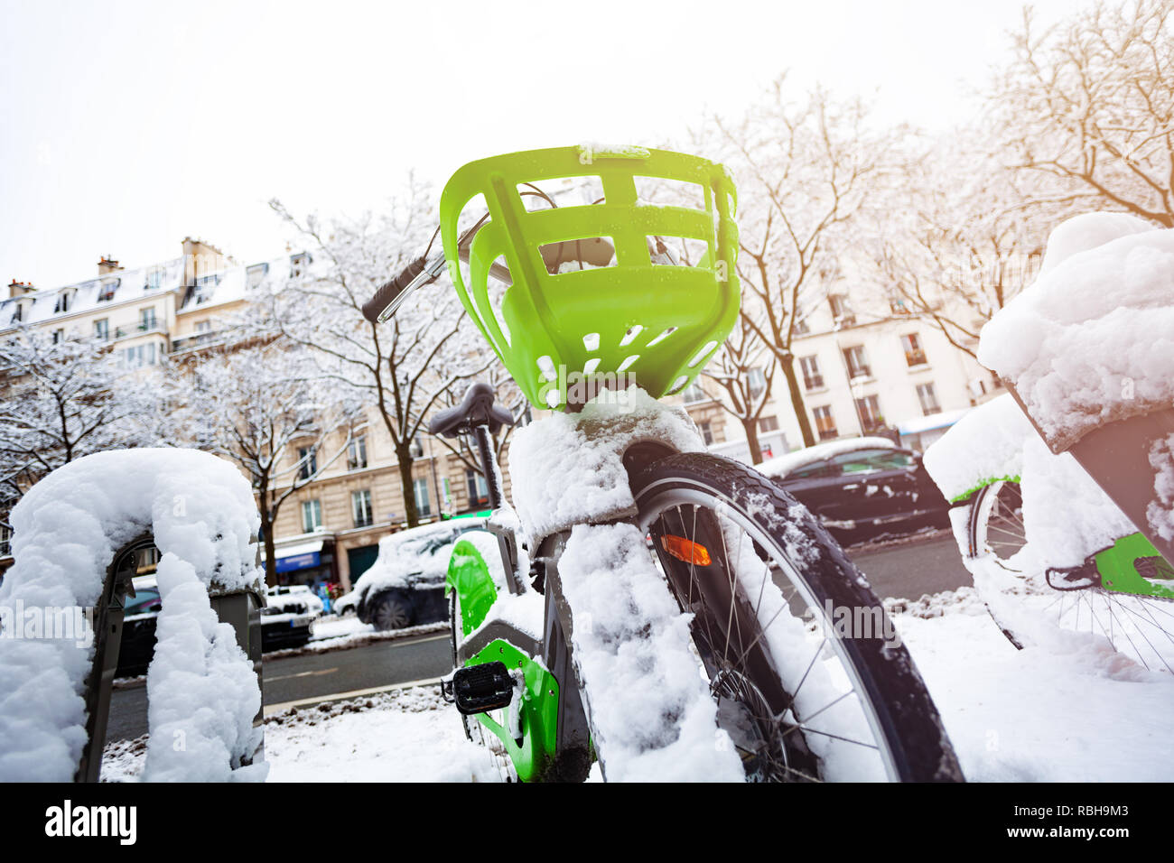 Schnee bedeckt Fahrrad auf dem Parkplatz in Paris Stockfoto