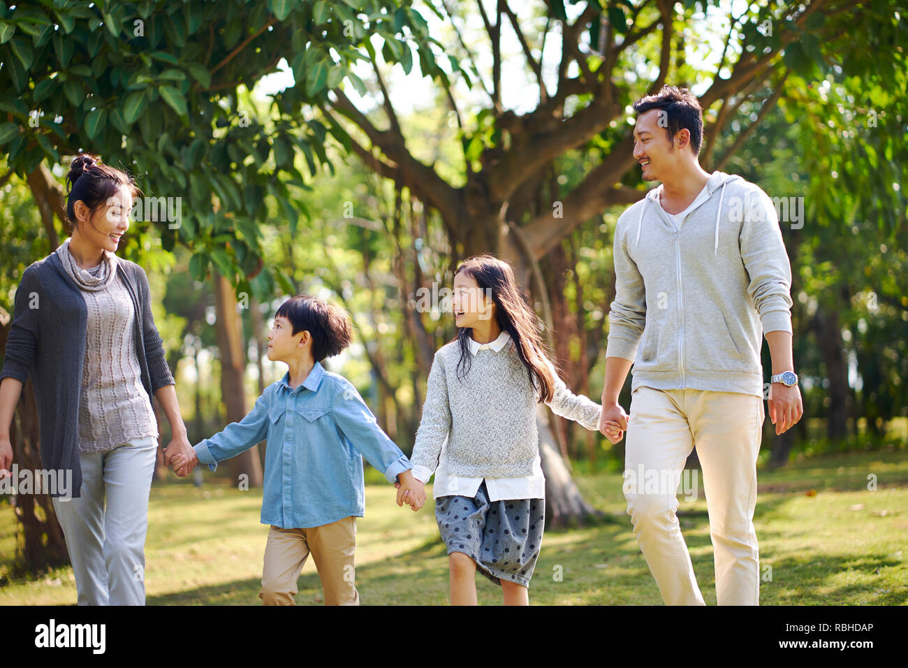 Asiatische Familie mit zwei Kindern Wandern entspannen im Park glücklich und lächelnd. Stockfoto