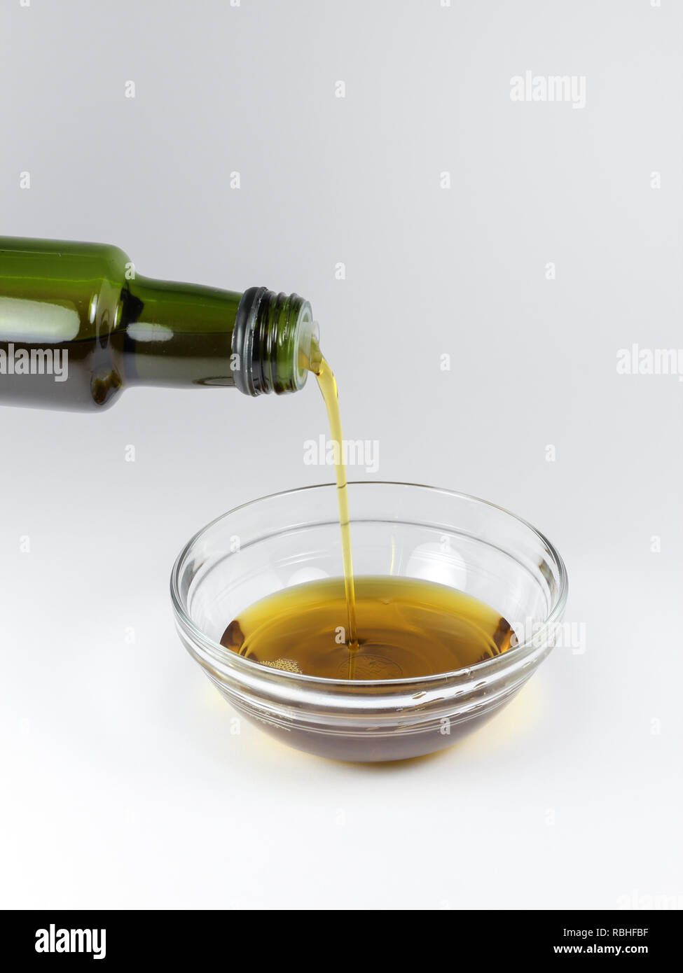 Das Gießen von einer Flasche organisches Hanfsamenöl auf weißem Hintergrund Stockfoto