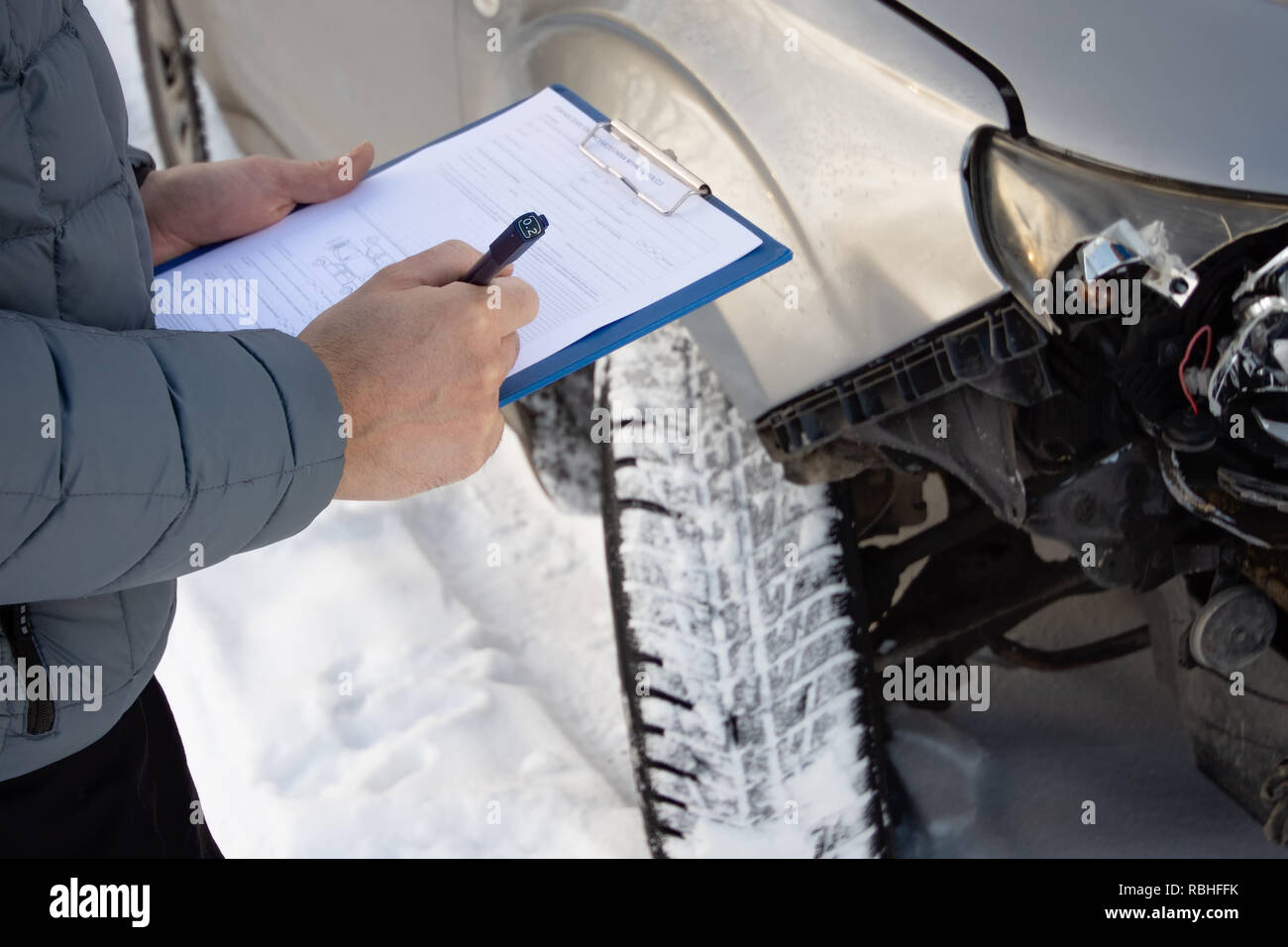 Versicherung Prüfung Auto nach Autounfall und Füllung Unfall Details bilden. Winter. Konzentrieren Sie sich auf die Hände. Stockfoto