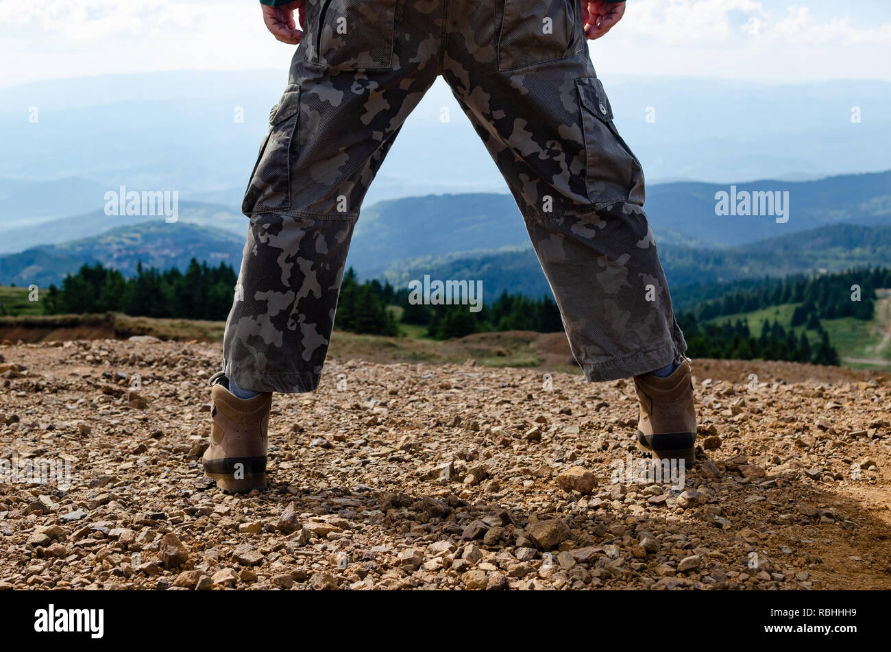 Mann verkleidet zum Wandern, stehend mit gespreizten Beine auf Kopaonik Berg in Serbien und die Landschaft Stockfoto
