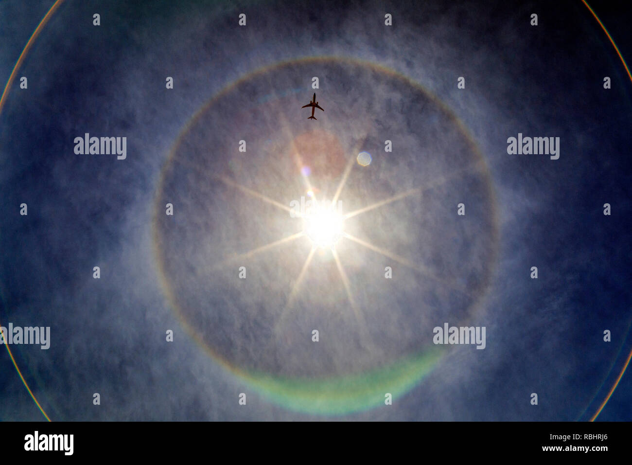 Flugzeug innerhalb des Kreises Regenbogen um die Sonne. Buenos Aires, Argentinien Stockfoto