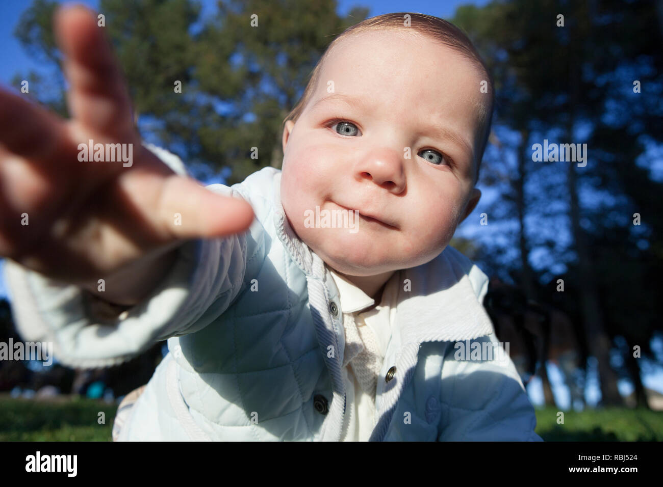 9 Monat baby boy versuchen Sie, die Kamera zu greifen. Er beginnt seine Vorliebe für seine rechte Hand zeigen Stockfoto