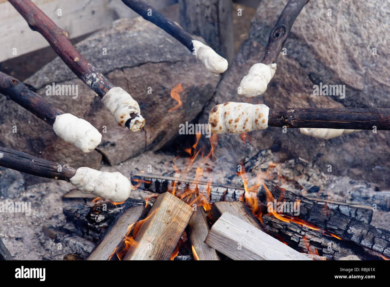 Kochen bannock Lagerfeuer Brot auf Stöcken über dem offenen Feuer Stockfoto