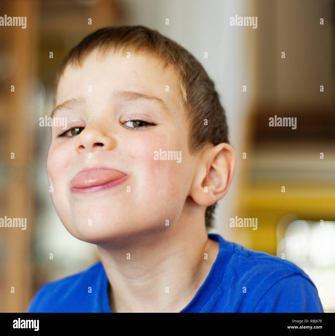 Ein Junge (6 Jahre alt) Gesichter ziehen an der Kamera Stockfoto