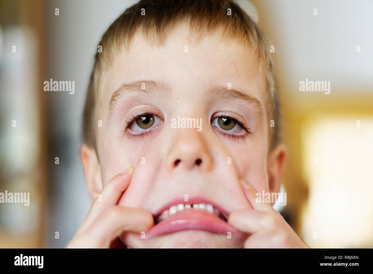Ein Junge (6 Jahre alt) Gesichter ziehen an der Kamera Stockfoto