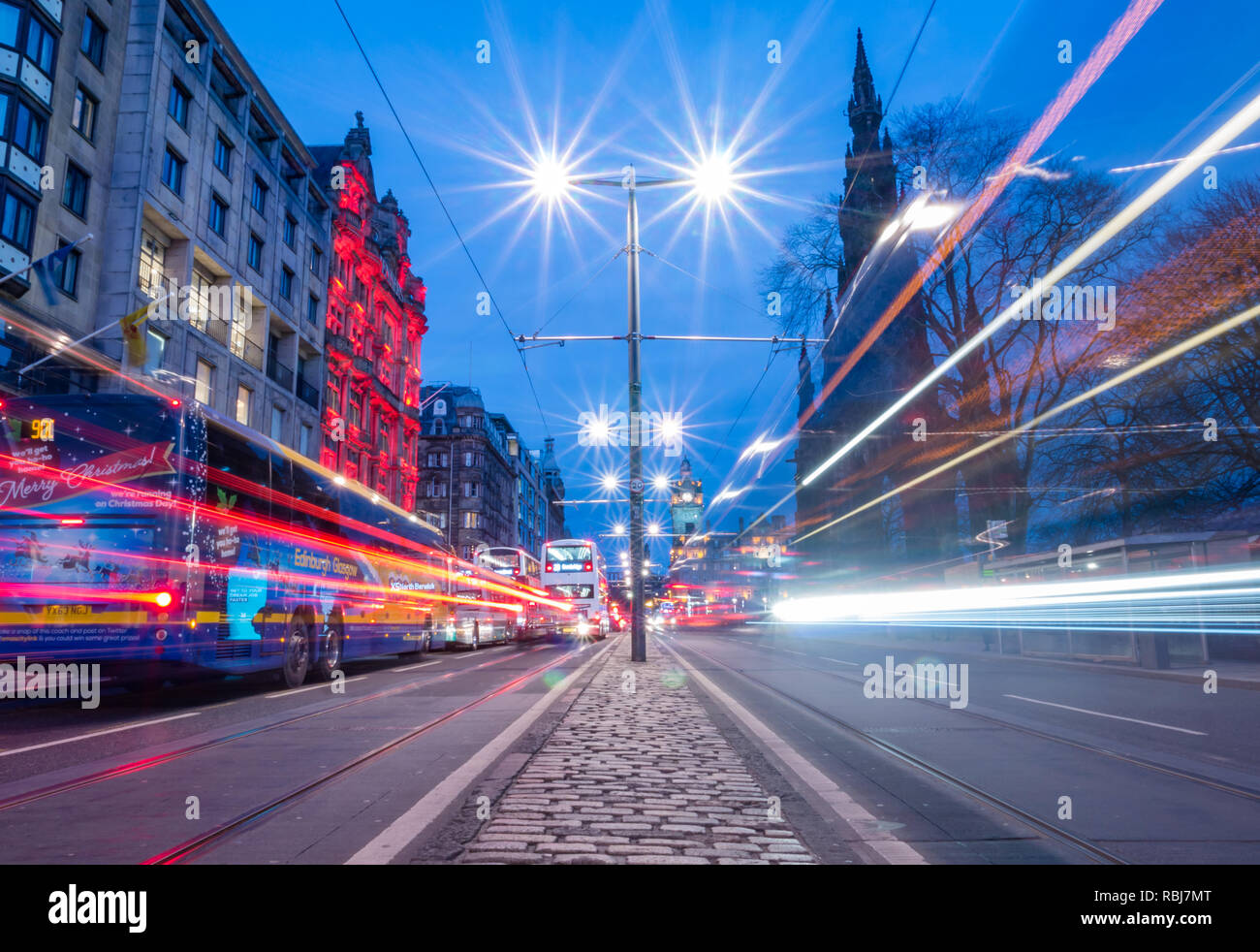 Nacht Spuren von Bussen und Straßenbahnen, die Princes Street, mit Balmoral Wecker und Scott Monument, Edinburgh, Schottland, Großbritannien Stockfoto