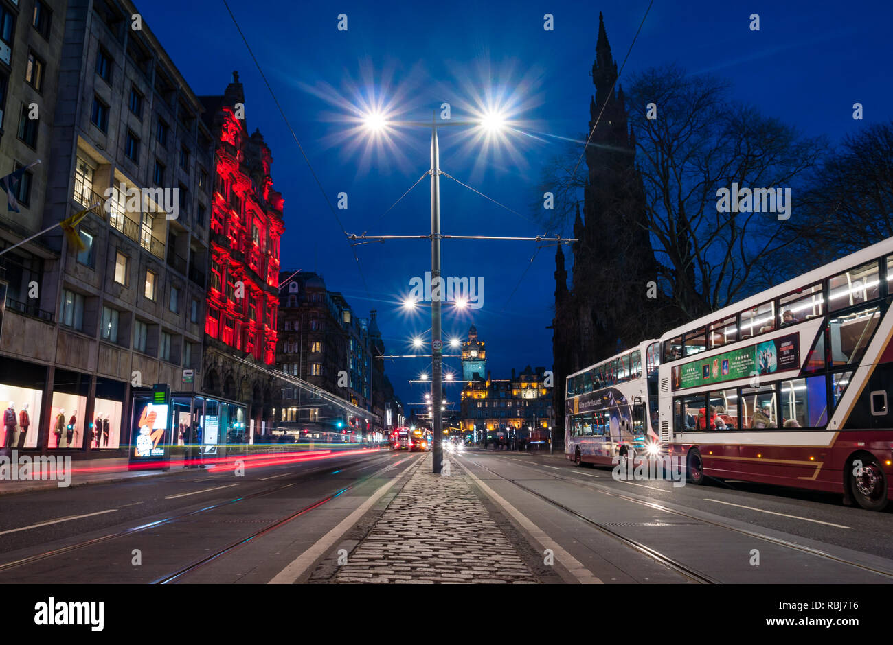 Nacht trails Princes Street in der Nacht mit Bussen, Balmoral Wecker und Scott Monument, Edinburgh, Schottland, Großbritannien Stockfoto