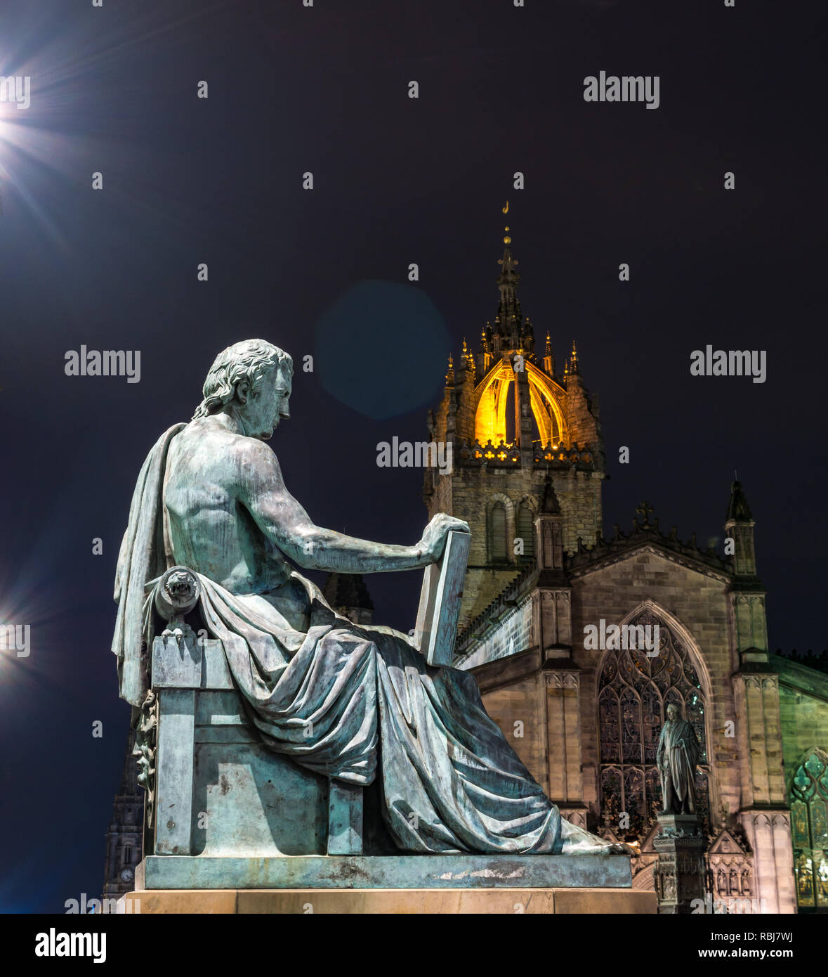 David Hume Statue von Alexander Stoddart leuchtet in der Nacht mit St Giles Kathedrale, Royal Mile, Edinburgh, Schottland, Großbritannien Stockfoto