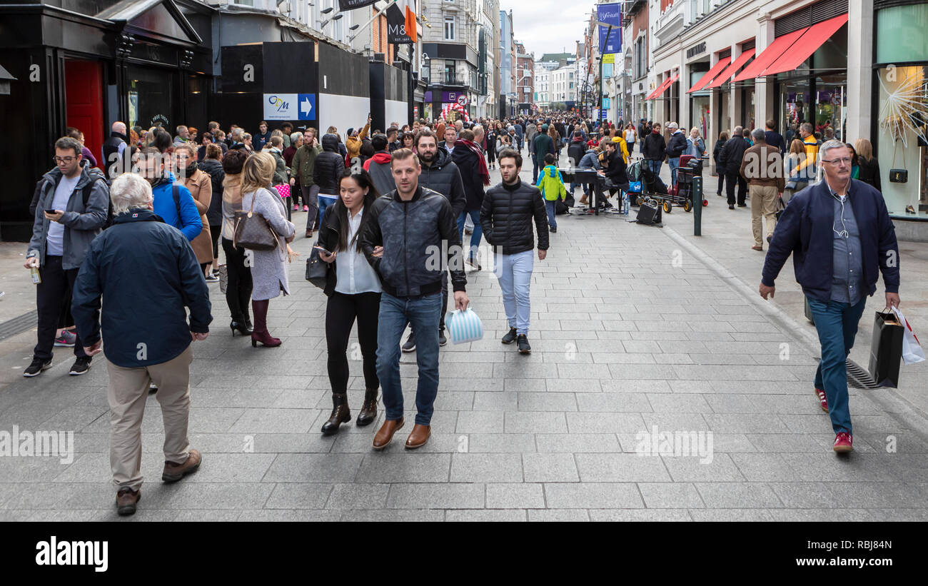 Menschen, Familien, Touristen zu Fuß und erkunden Sie die Grafton Street, einer belebten Geschäftsstraße in Dublin, Irland. Stockfoto