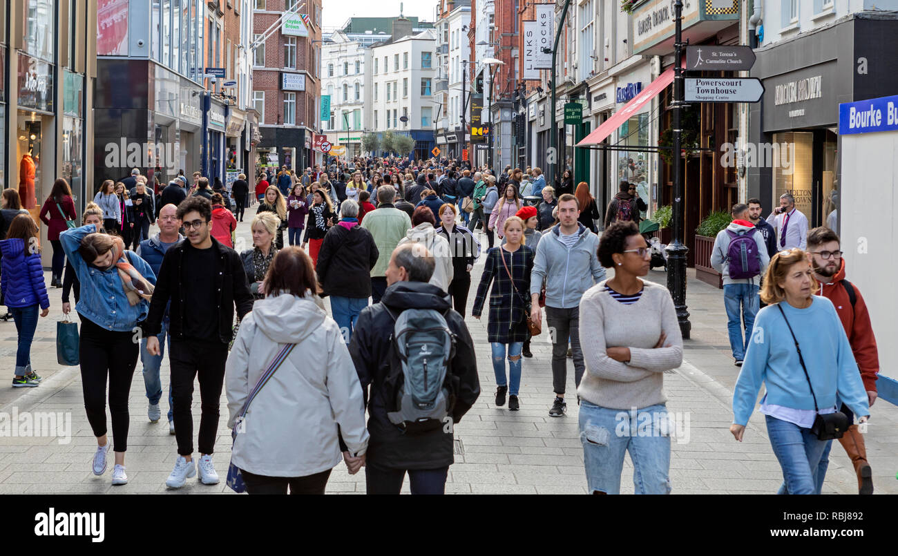 Menschen, Familien, Touristen zu Fuß und erkunden Sie die Grafton Street, einer belebten Geschäftsstraße in Dublin, Irland. Stockfoto