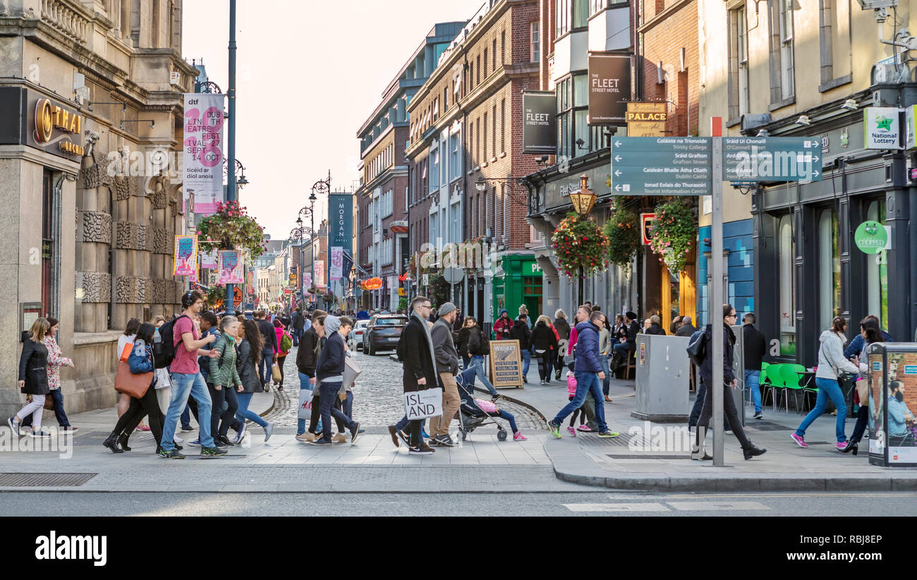 Menschen, Familien, Touristen zu Fuß und erkunden Fleet St., einer belebten Geschäftsstraße in Dublin, Irland. Stockfoto