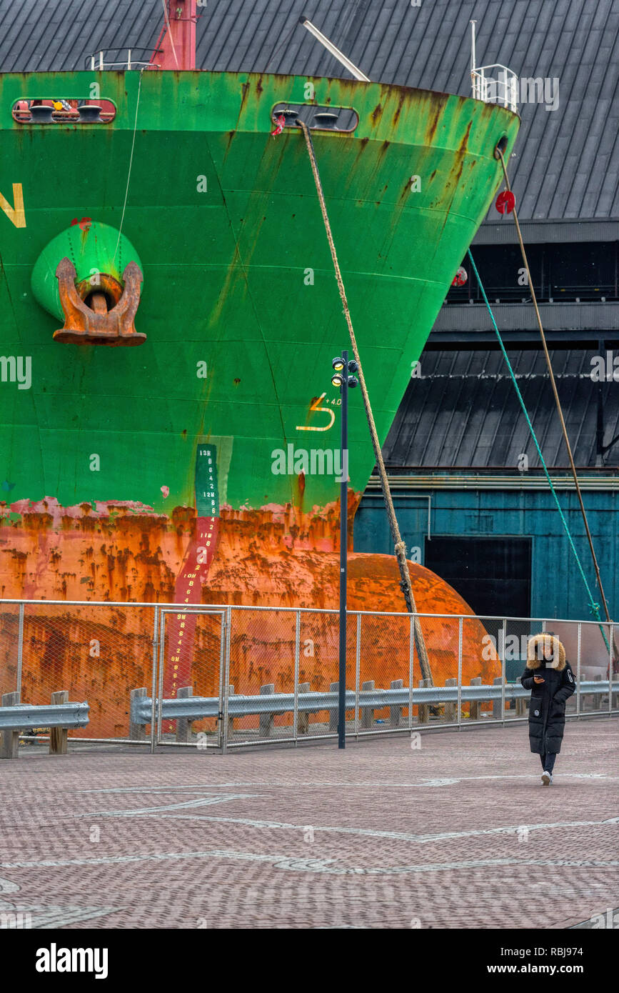 Eine junge Frau, die Fußgängerzone vorbei an der bulk carrier Schiff Hafen Pfeifente in Toronto, Kanada Stockfoto