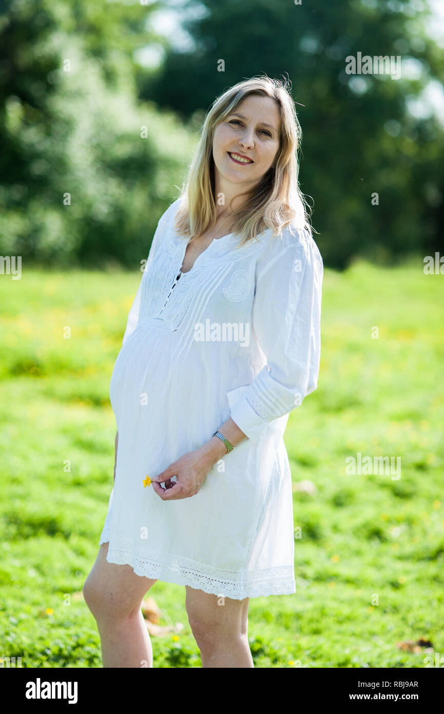 Schwangere Frau mit ihren Bauch und Lächeln Stockfoto