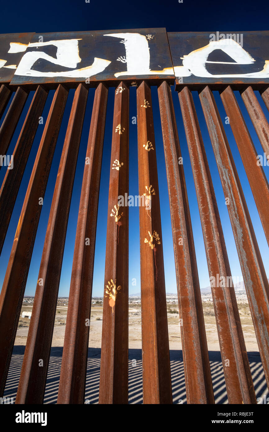 Vertikale Bild der USA Mexiko Grenzzaun zwischen El Paso und Juarez von der mexikanischen Seite. Hand Drucke sind auf eine der Spalten gestrichen. Stockfoto