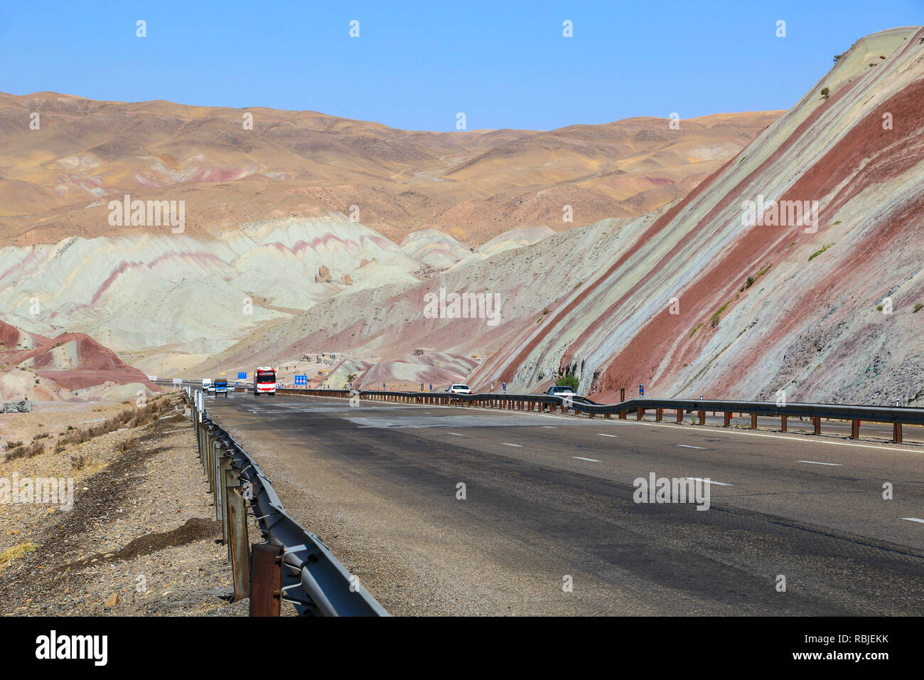 Autos fahren auf der Autobahn durch die schönen bunten Berge ähnlich östlichen Gewürzen in Tabriz, Iran Stockfoto