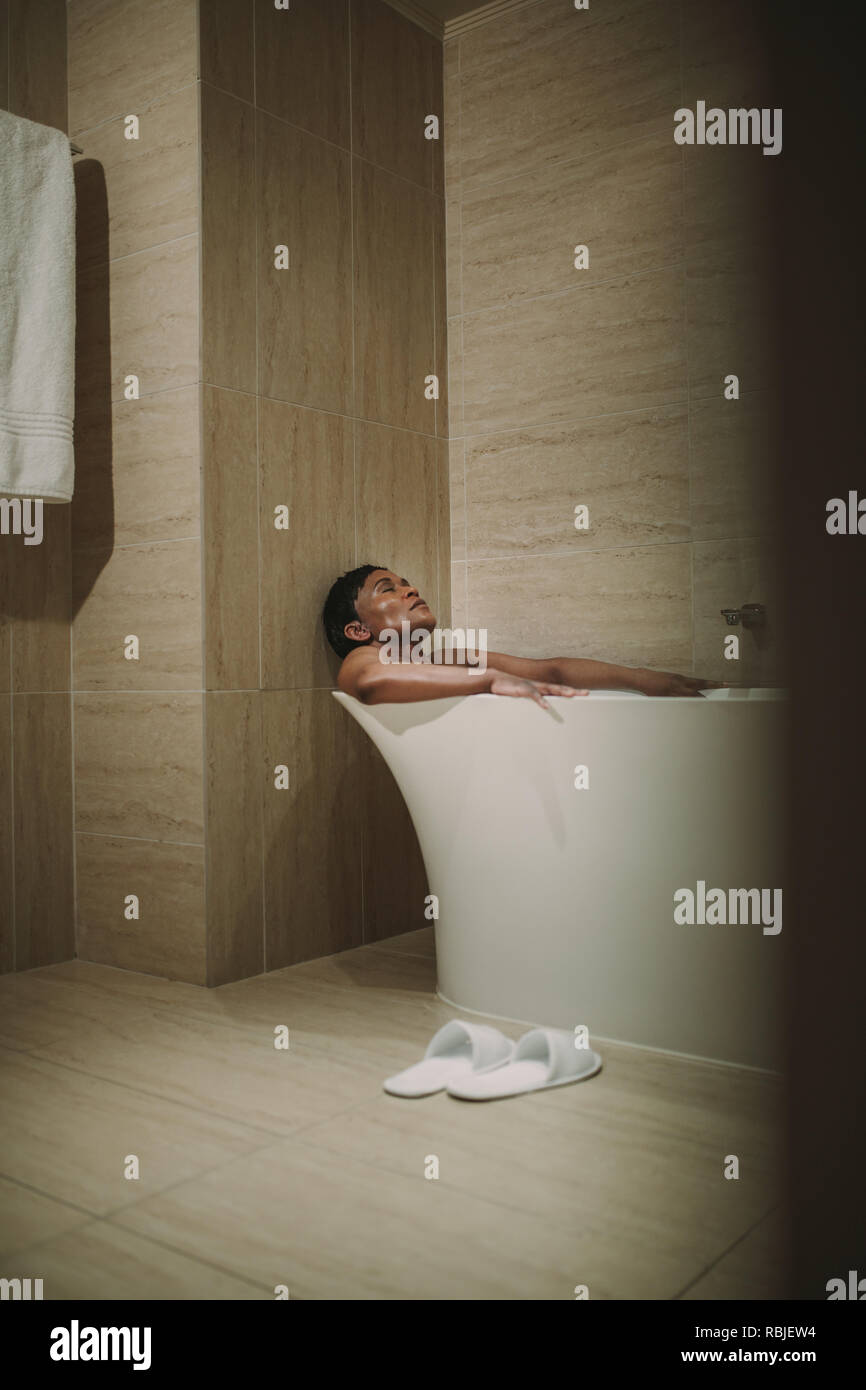Afrikanische Frau in Badewanne im Bad. Reife weibliche unter Bad in der Badewanne. Stockfoto