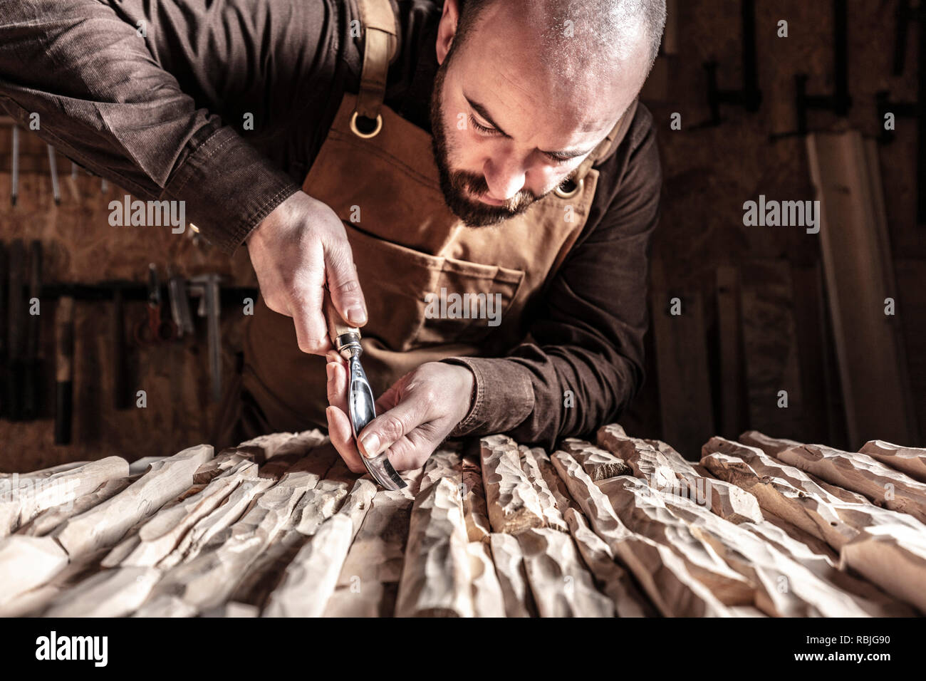 Kaukasische Tischler schnitzen Holz mit Kollisionsprüfung Stockfoto