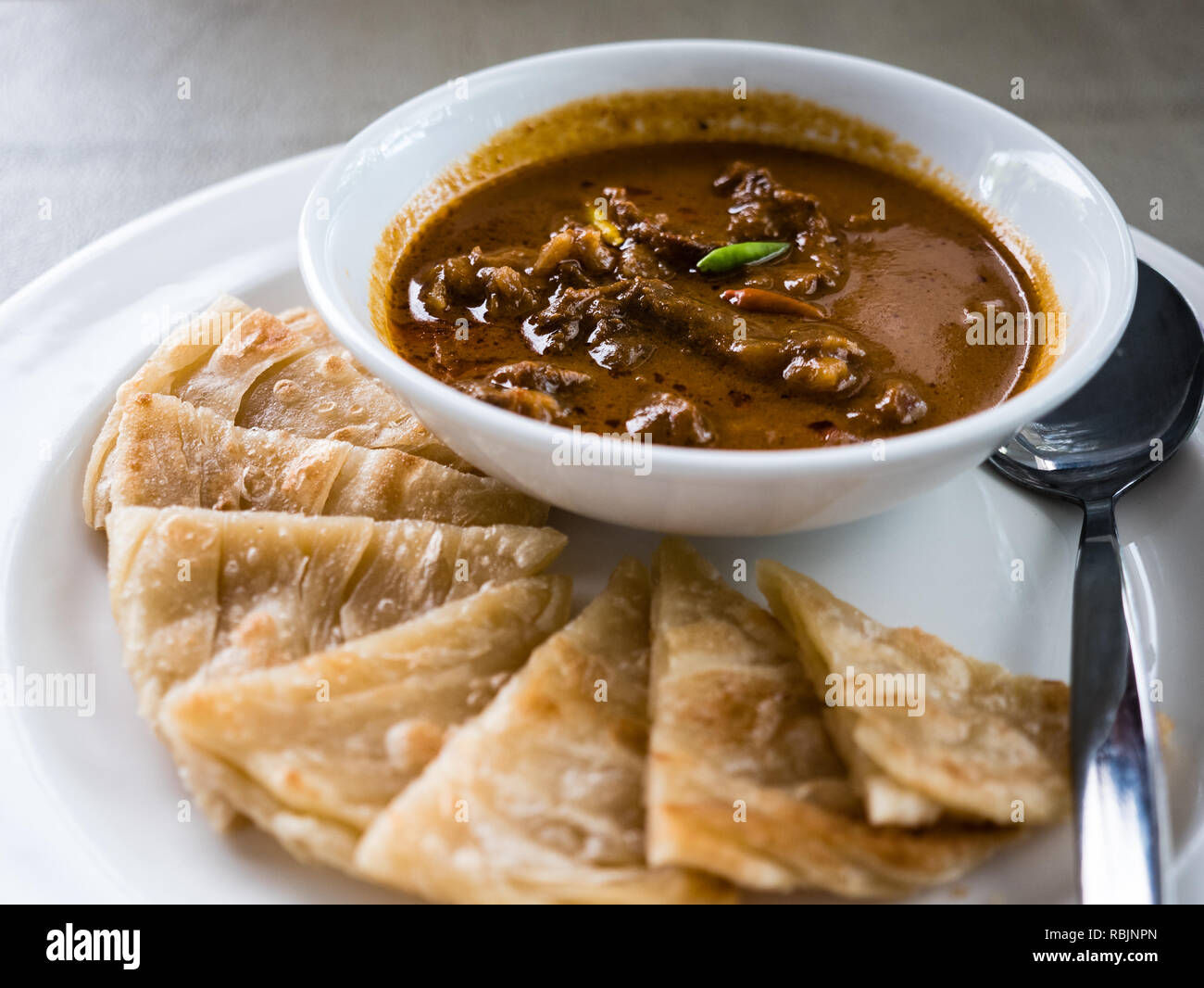 Gebratene Ente in rotem Curry mit Roti Stockfoto