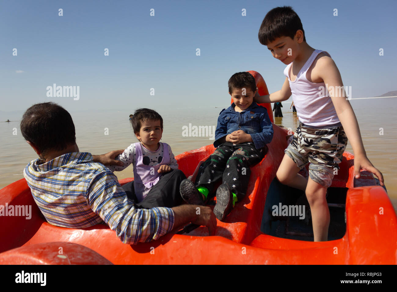 Ein Mann reitet ein Tretboot mit seinen Kindern auf dem Urmia See, West Provinz Aserbaidschan, Iran Stockfoto