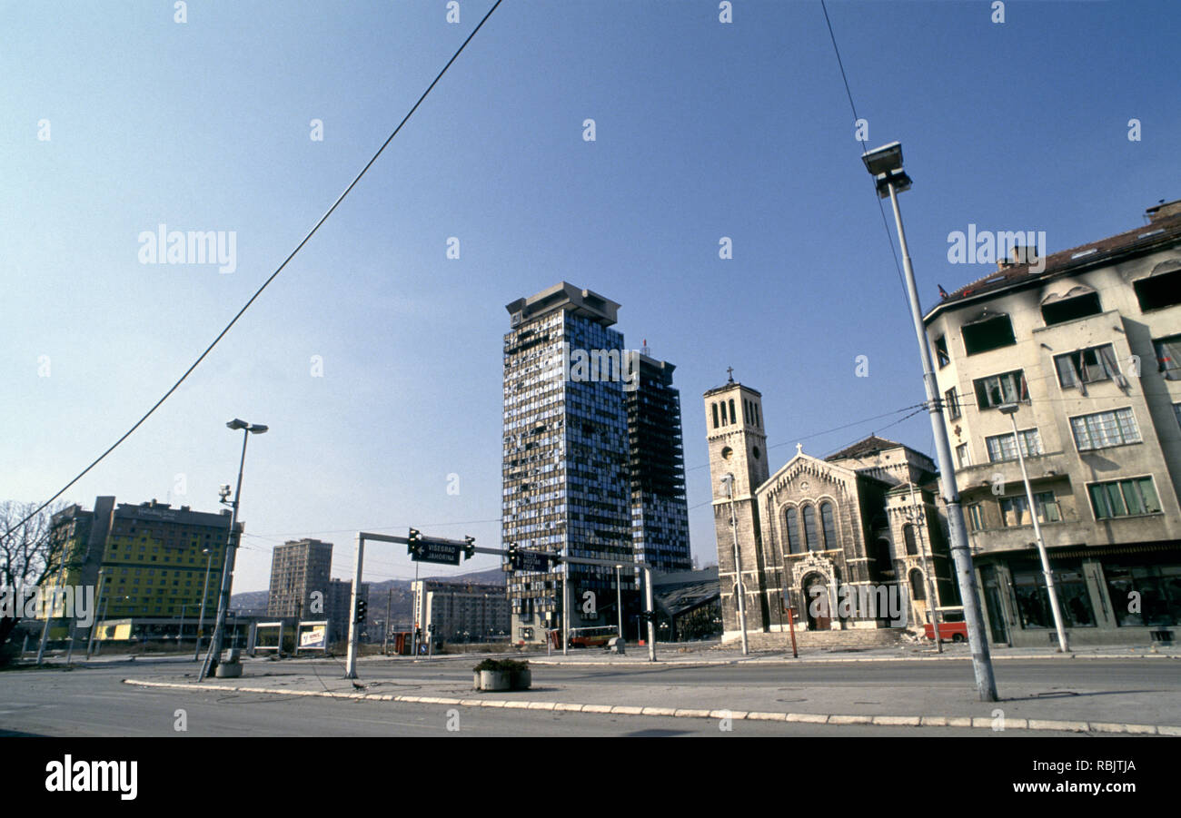 15. März 1993 während der Belagerung von Sarajevo: das Holiday Inn, Unis, Türme und Saint Joseph's Kirche auf einer verlassenen Sniper Alley. Stockfoto