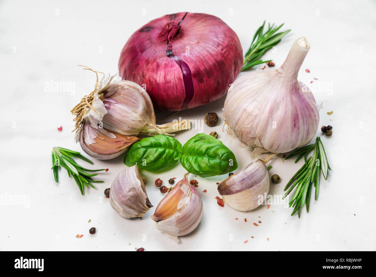 Mit roten Zwiebeln, Knoblauch, Basilikum, Rosmarin und Pfeffer auf weißem Hintergrund.. Kochen Konzept Stockfoto