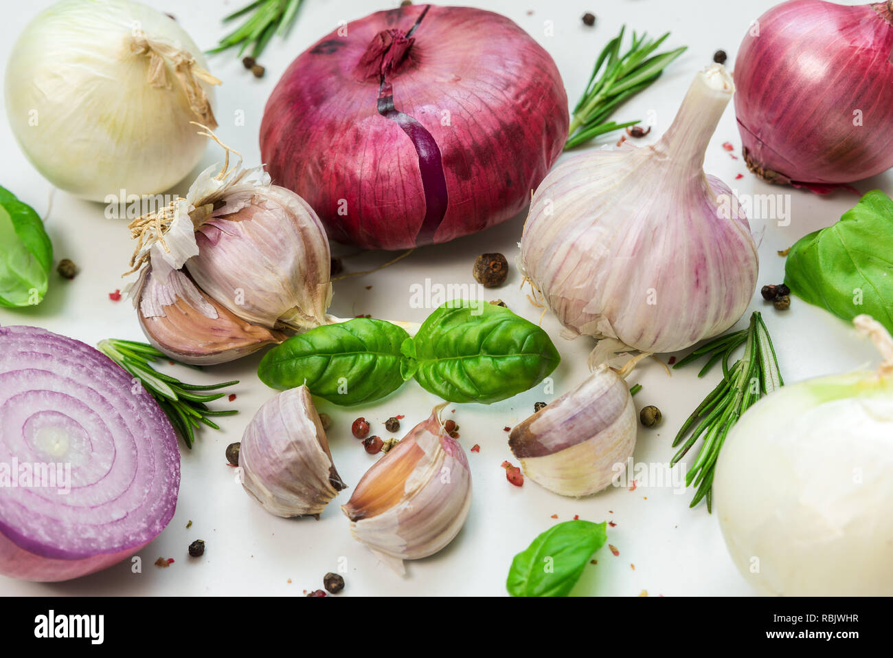 Knoblauch, Zwiebeln, Basilikum, Rosmarin und Pfeffer auf weißem Hintergrund.. Kochen Konzept Stockfoto