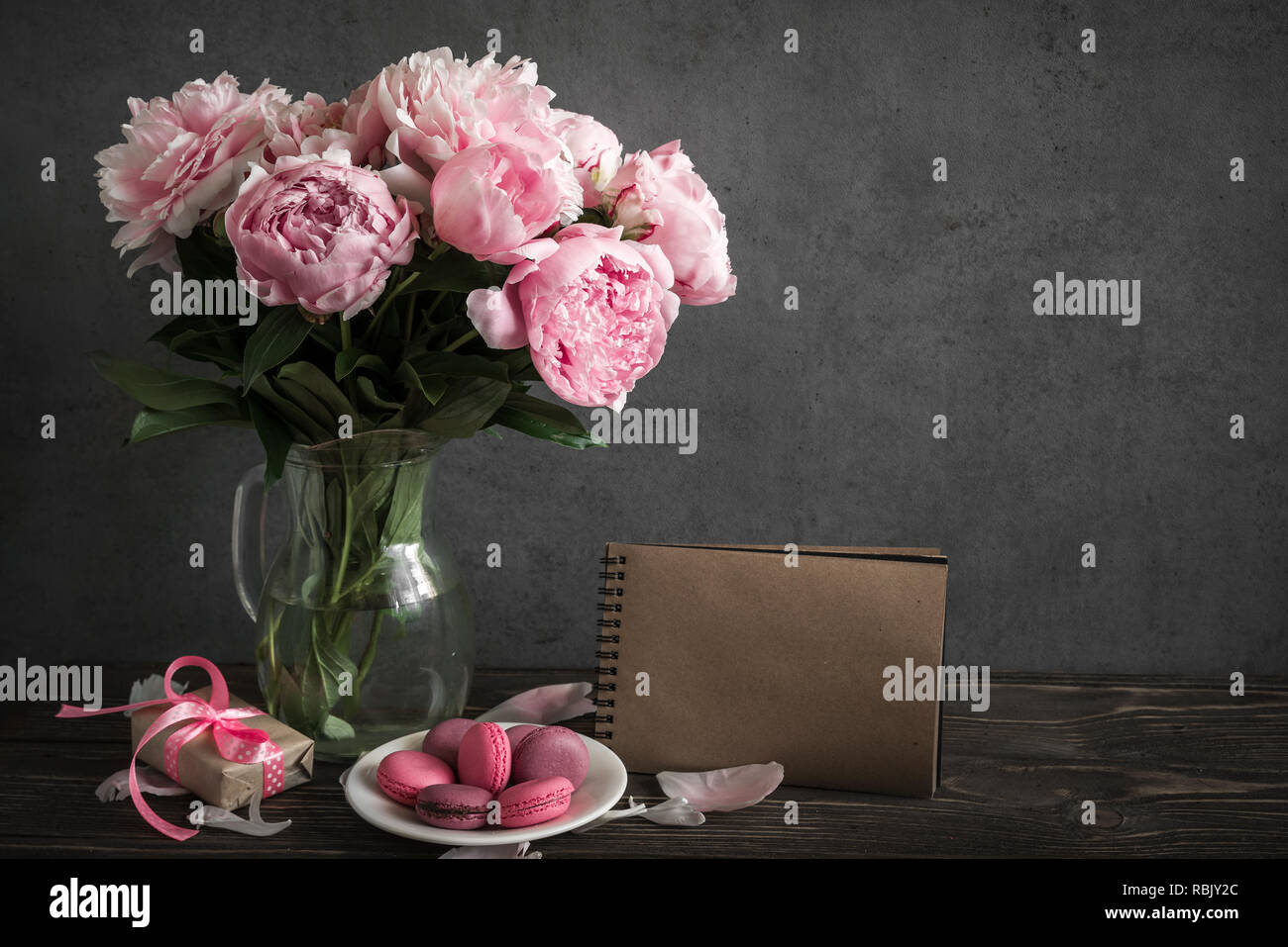 Kreative mock up mit einem schönen Blumenstrauß rosa Pfingstrose Blumen, Geschenkbox, Makronen und vintage Notebook mit Platz für Text. Urlaub oder Hochzeit zurück Stockfoto
