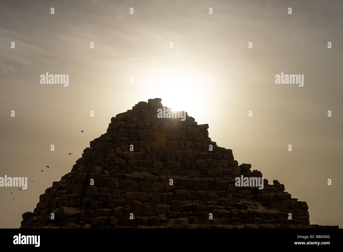 Das Grab der Königin Hetepheres in der Pyramide von Gizeh Komplex mit Sterne Strahlen der aufgehenden Sonne hinter sich und Tauben wegfliegen. Königin Hetepheres war ich ein Stockfoto