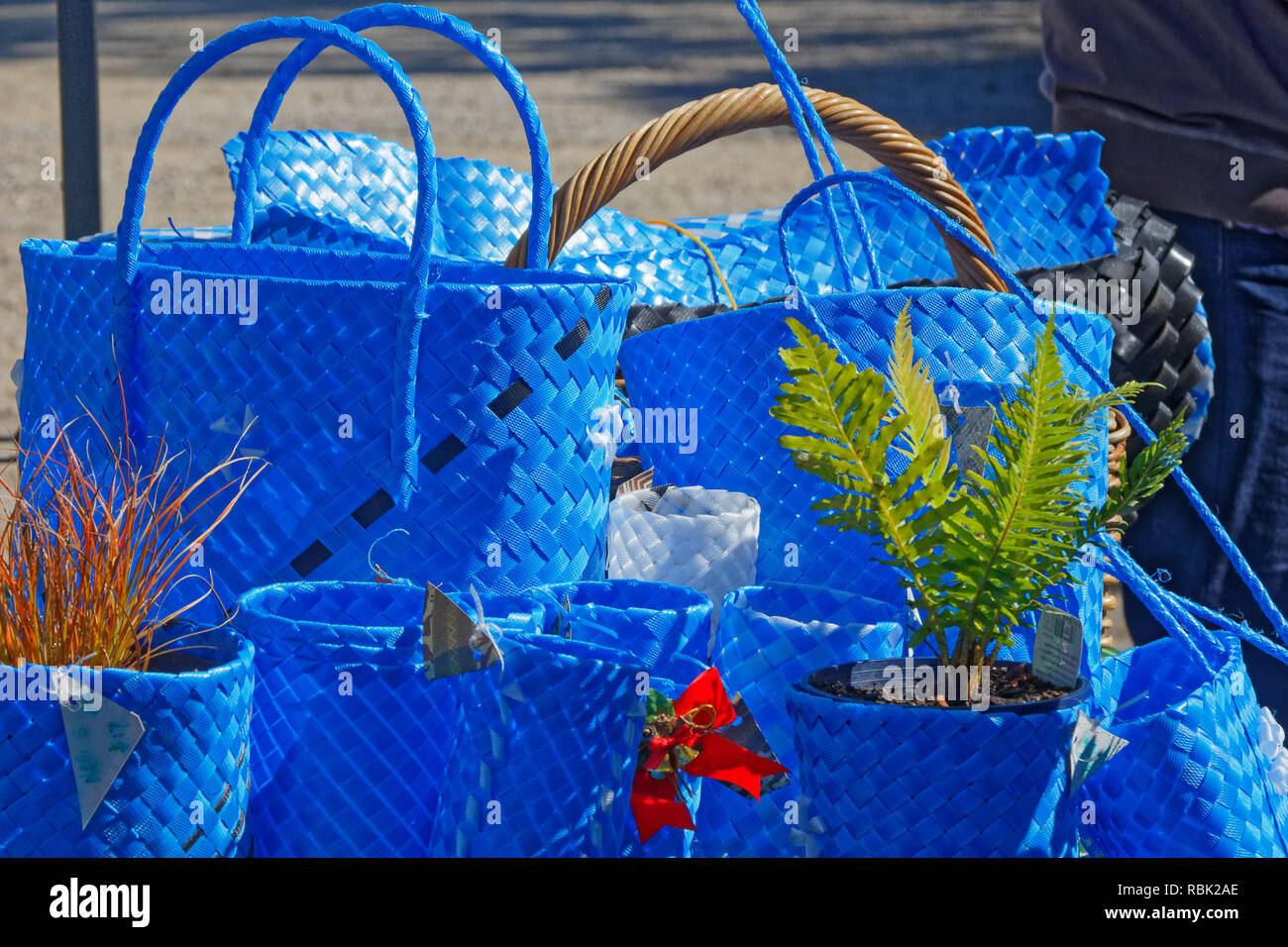 Blaue Einkaufstaschen, Warenkörbe, und Blumentopf Inhaber von upcycled Verpackungen Armband Materialien auf einem Marktstand Stockfoto