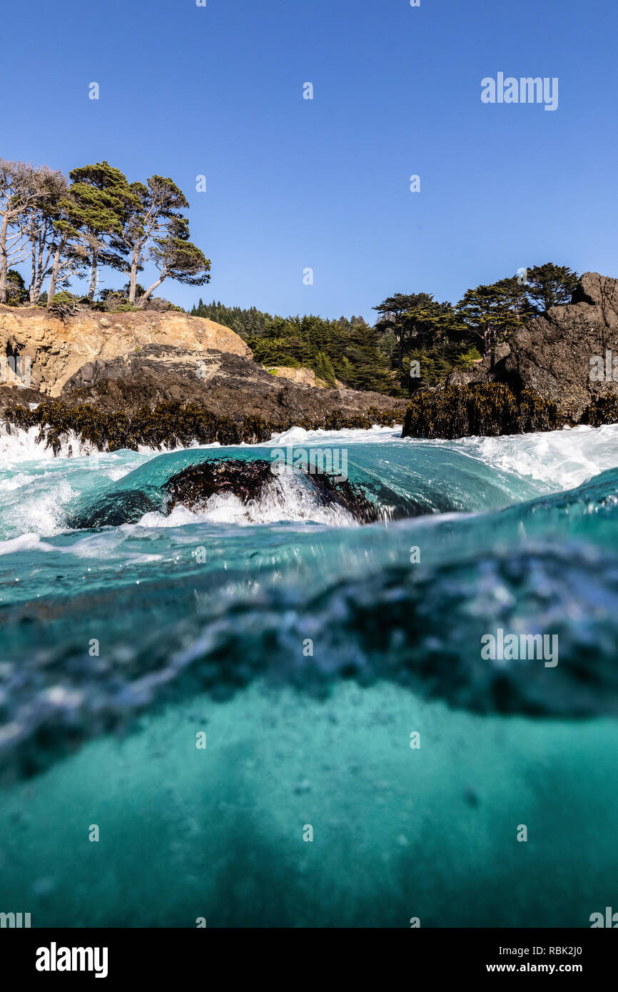 Eine Welle bricht über einen Waschgang Rock in Russian Gulch State Park. Stockfoto