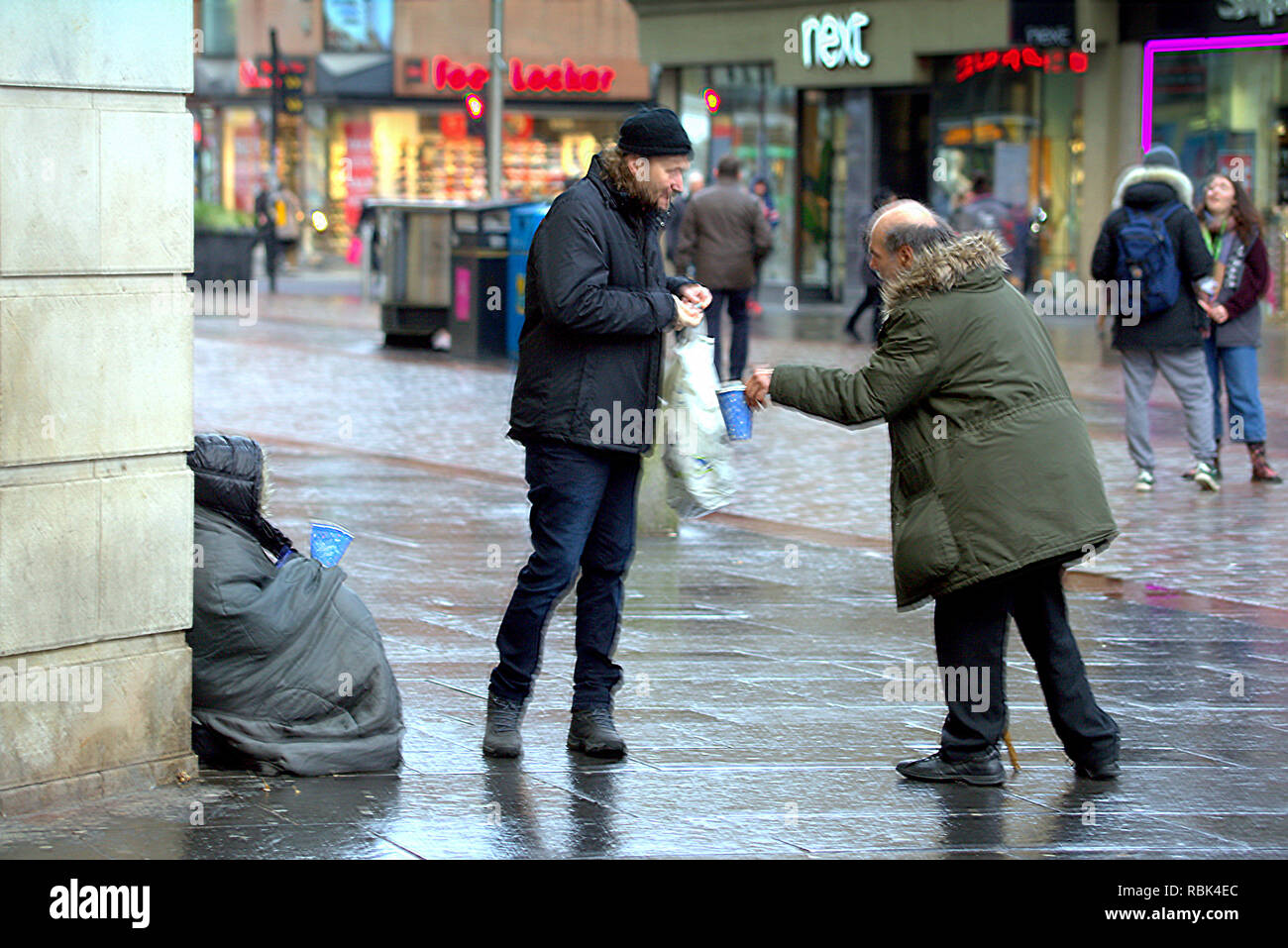 Obdachlosen armen Person Betteln nicht identifizierbare auf dem nassen Argyle Street Einkaufsviertel Glasgow Schottland Großbritannien Stockfoto