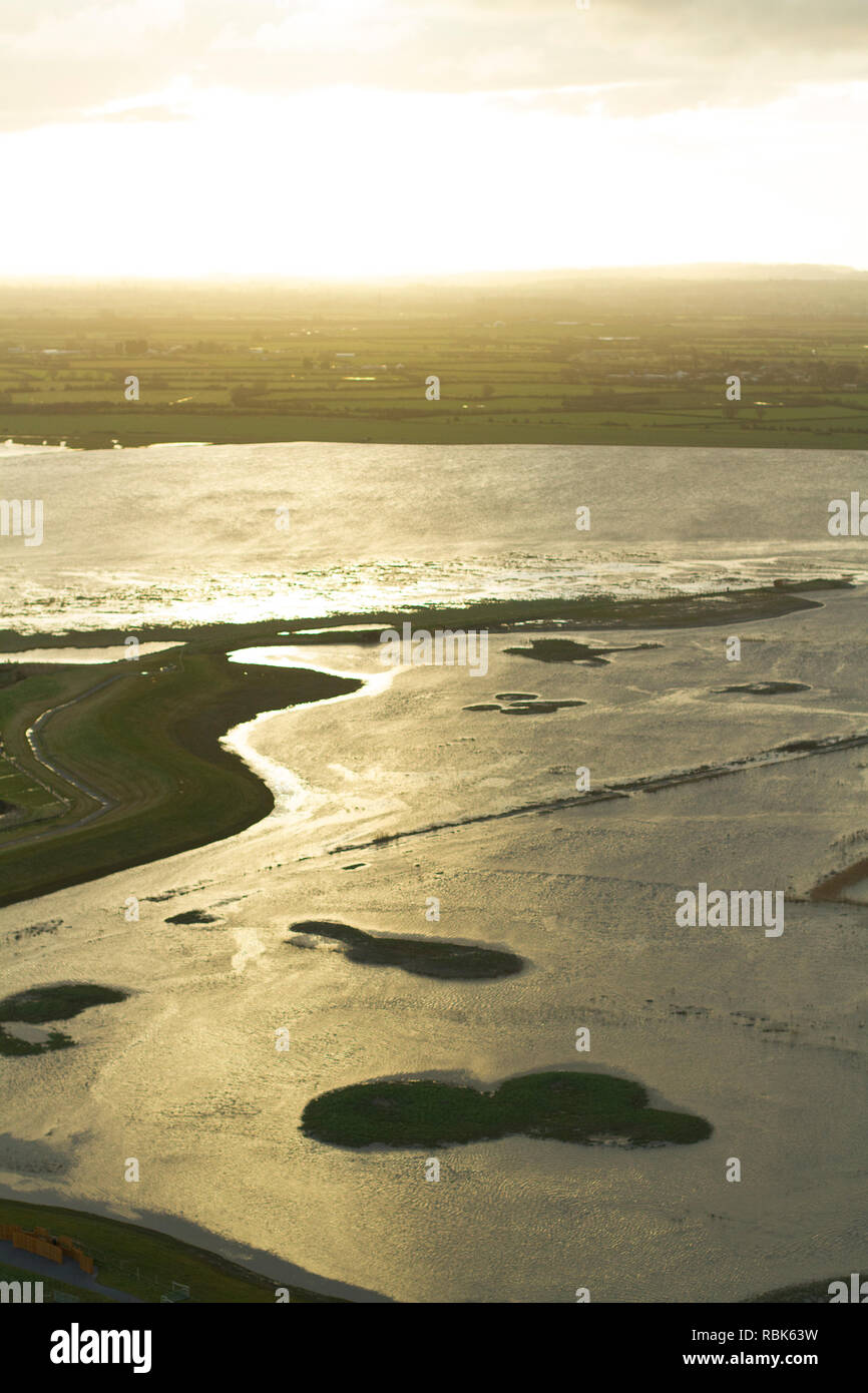 Luftaufnahme von Steart Sümpfen und Feuchtgebieten Wildfowl Trust, landwirtschaftliche Flächen in Wetland Reserve umgewandelt, bei Sonnenaufgang, Somerset, Großbritannien, Februar 2015. Dieser Bereich hat die Flut erlaubt neue Salzwiesen Lebensraum zu schaffen, und ist ein Beispiel für Managed Rückzug. Stockfoto