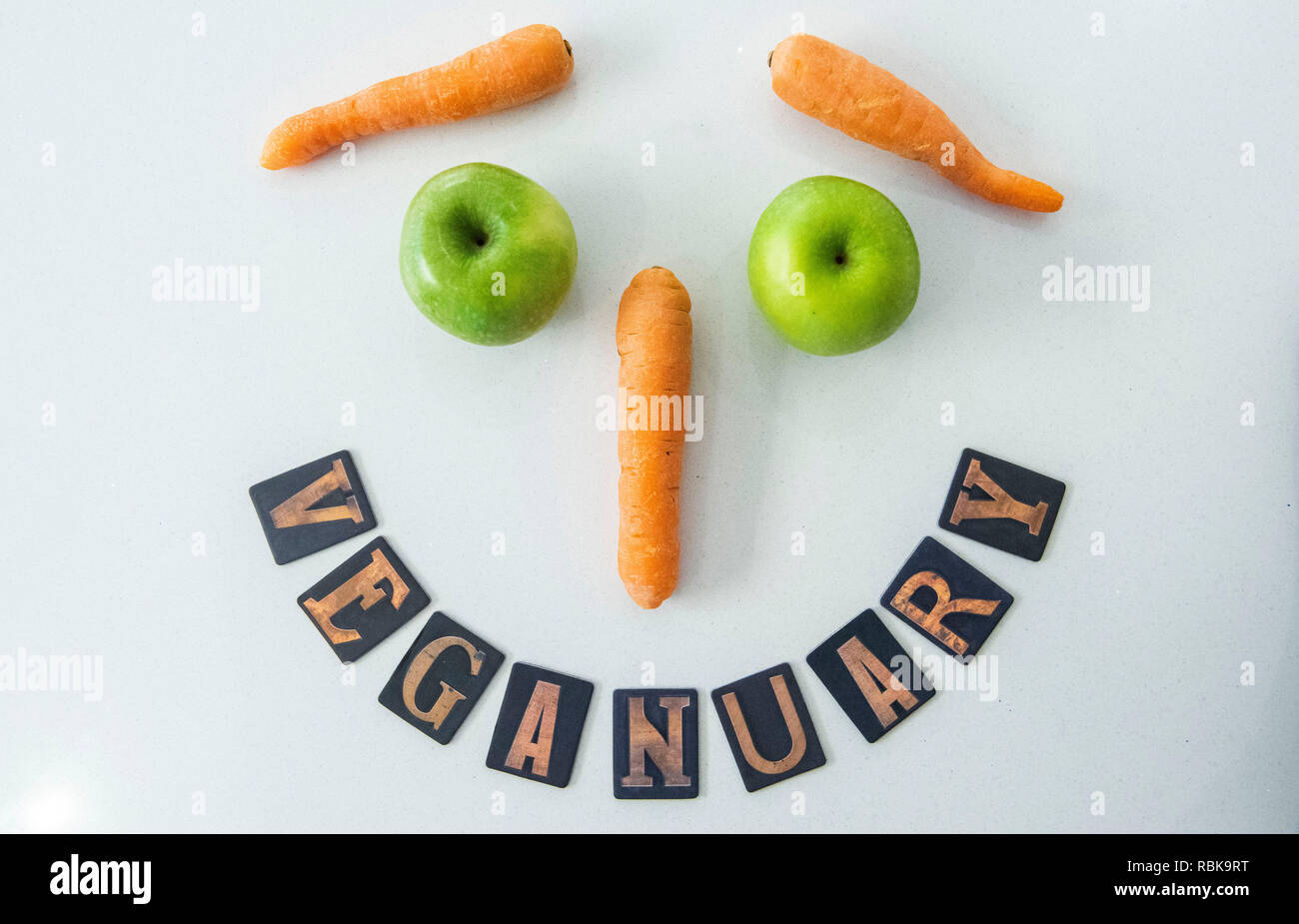 Zeichen für Veganuary mit Karotten und Äpfel. Stockfoto