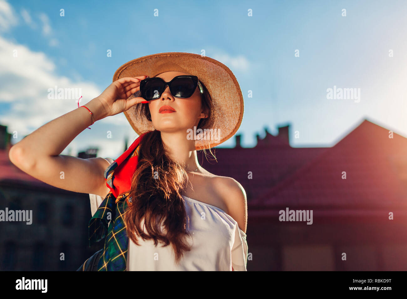 Junge elegante Frau mit Hut und Sonnenbrille im Freien. Stilvolle Mädchen mit Rucksack wandern in Lemberg tragen retro Outfit Stockfoto