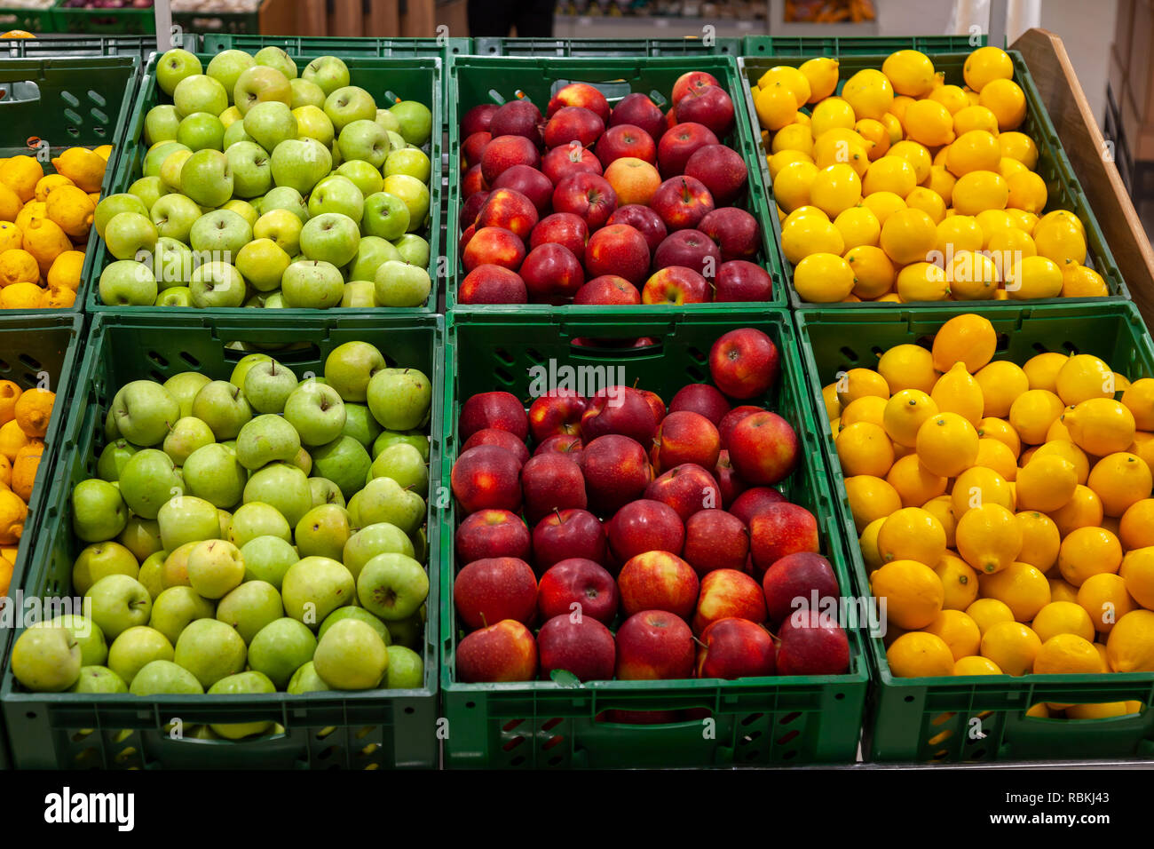 Ein großes Regal mit Körben mit verschiedenen Arten von Äpfel und Zitronen im Obst Abteilung der Shopping Center. Frische und gesunde Lebensmittel für alle Stockfoto
