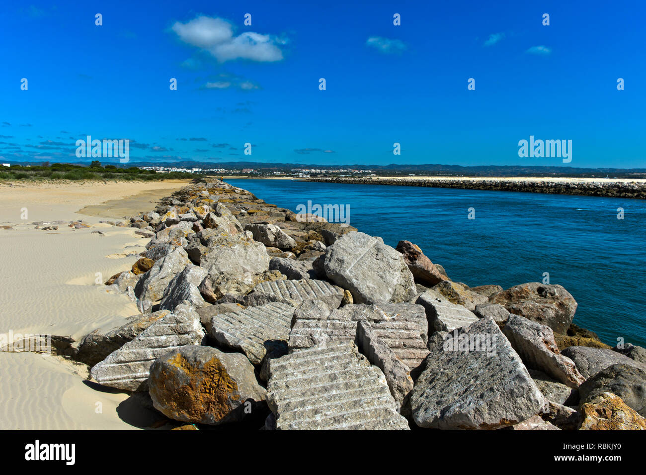 Felsbrocken als Schutz der litoral Zone gegen den Anstieg des Meeresspiegels an der Mündung des Fluss Gilao, Tavira Insel Ilha de Tavira, Tavira, Algarve, Stockfoto