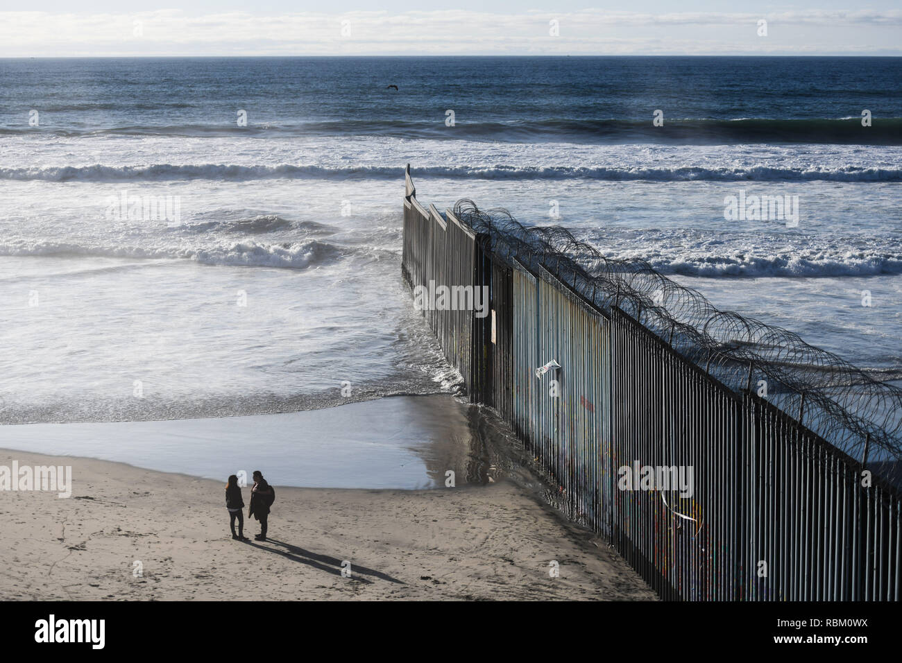 Tijuana. 10 Jan, 2019. Foto auf Jan. 10, 2019 Leute zeigt, die neben der US-mexikanischen Grenze Barriere in Tijuana, Mexiko. Eine große Zahl von Migranten aus Zentralamerika haben den Umweg um die Grenze Barriere nicht in die Vereinigten Staaten zu kommen. Credit: Xin Yuewei/Xinhua/Alamy leben Nachrichten Stockfoto